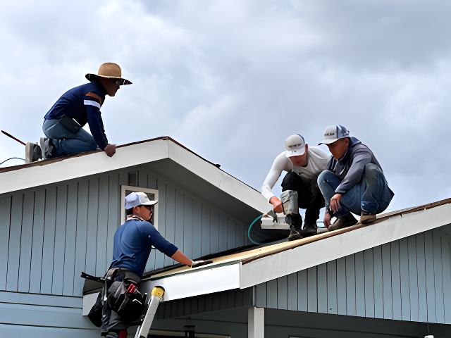 Four men working on the roof of a house